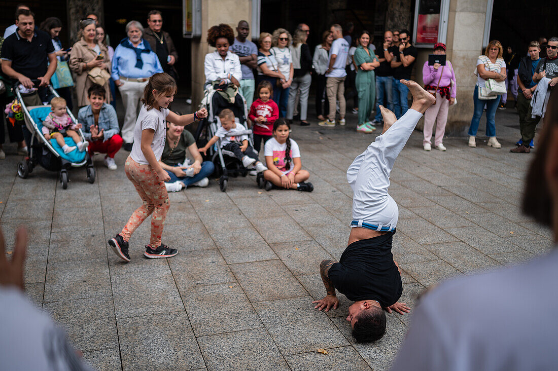 Mitglieder der Mestre Branco Capoeira Escola demonstrieren auf der Straße während der Fiestas von El Pilar in Zaragoza, Aragonien, Spanien