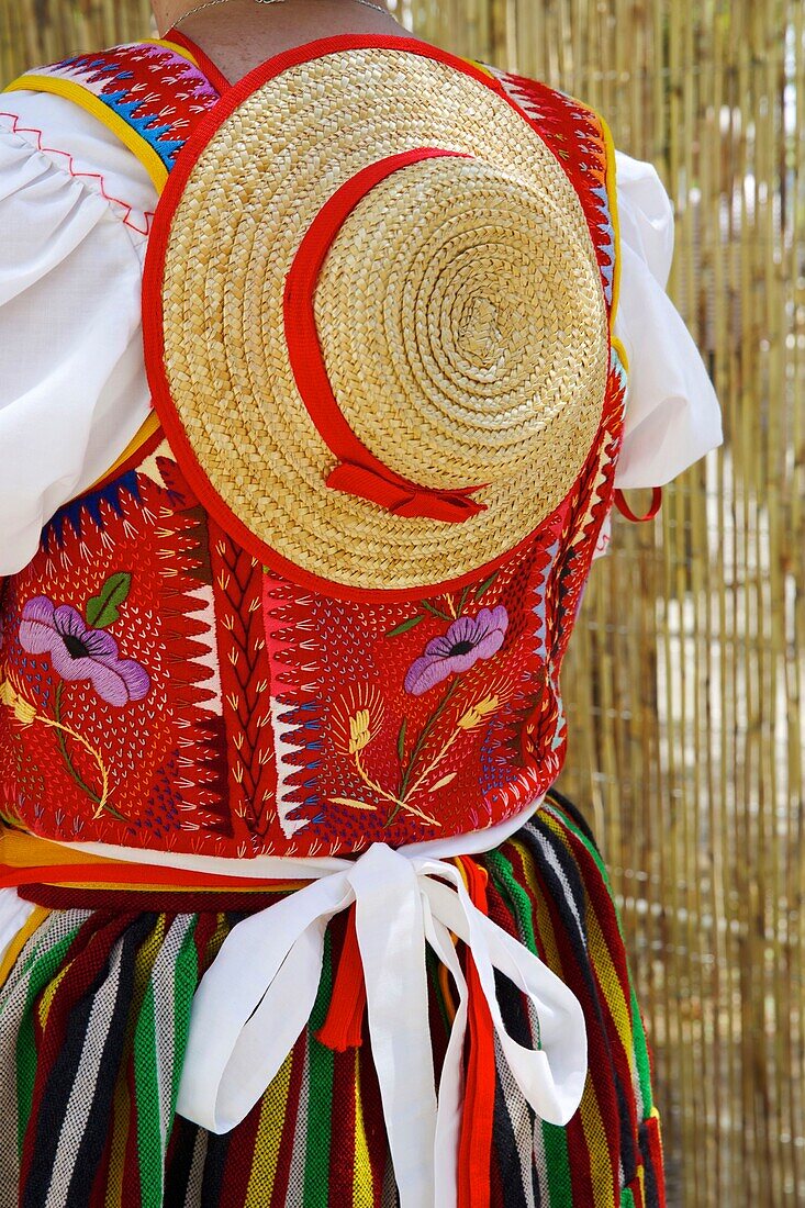 Spanien, Kanarische Inseln, Insel Teneriffa, mit bunten Blumen bestickte Bluse und traditioneller Strohhut, getragen von einer Frau während einer romería, einer traditionellen Feier