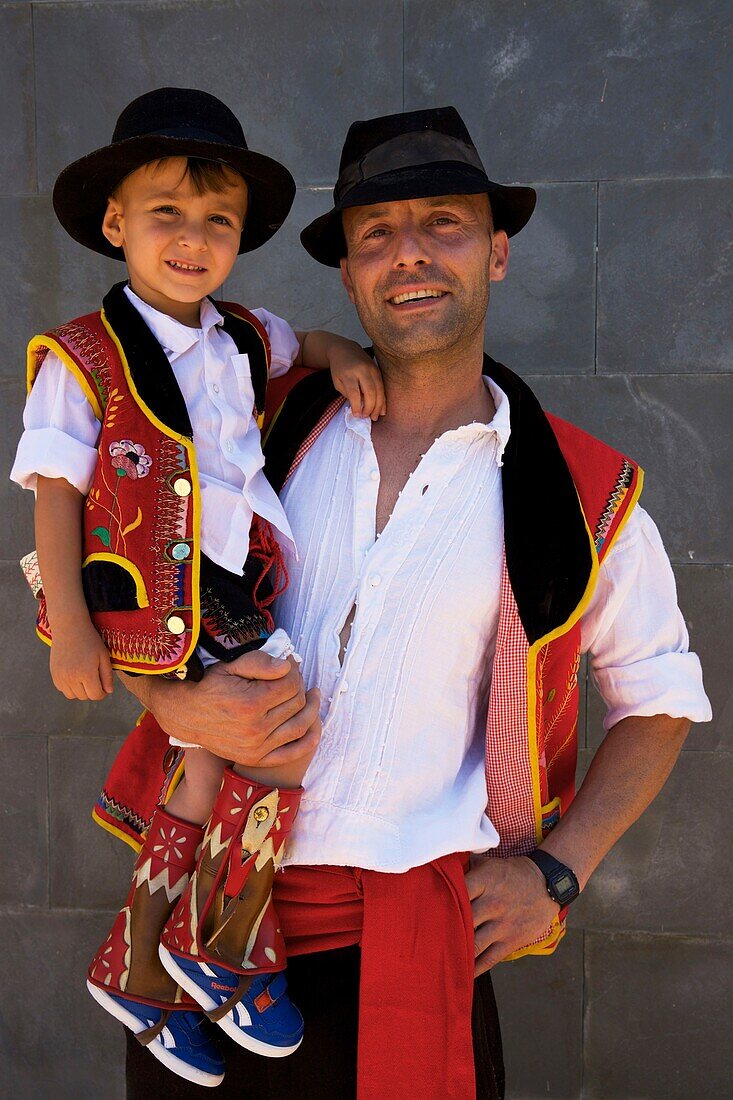 Spanien, Kanarische Inseln, Insel Teneriffa, Mann und sein kleiner Junge in den Armen in traditioneller kanarischer Tracht während einer romería, einem traditionellen Fest