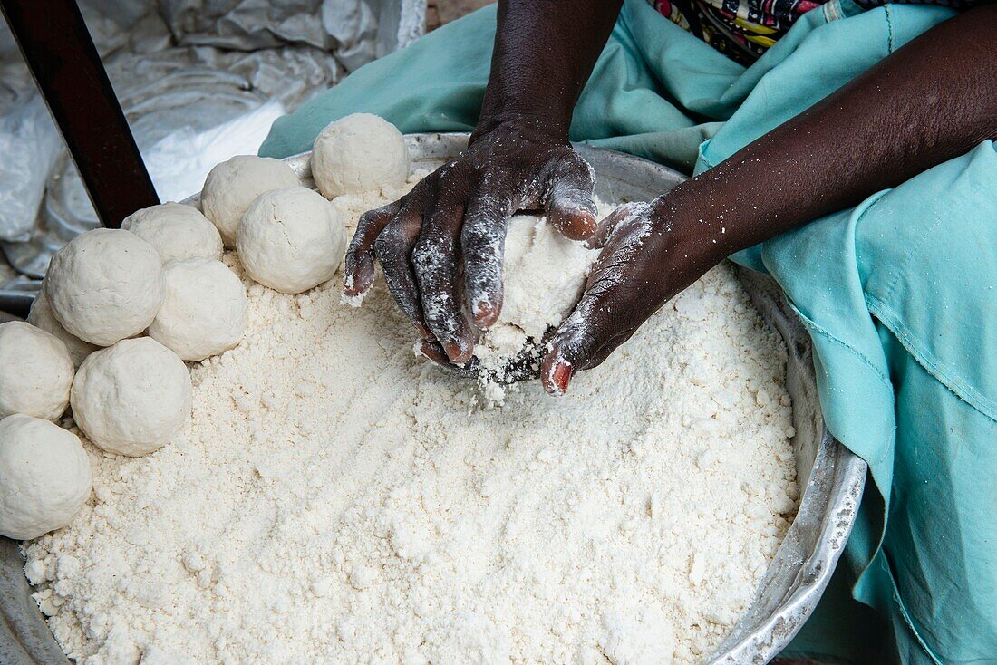 Benin, Cotonou, Woman kneading manioc flour to make balls