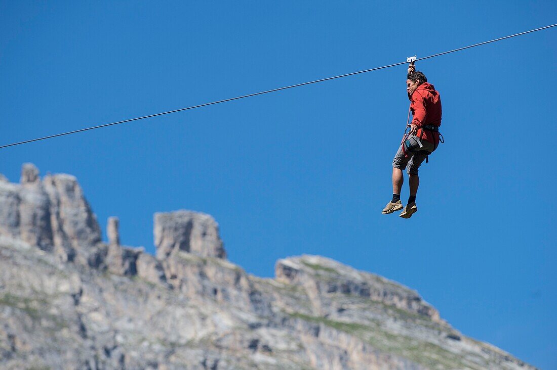 France, Savoie, mountain of Vanoise, Pralognan la Vanoise, a person on zip line cable crosses the valley of the Gliere and the teeth of Portetta