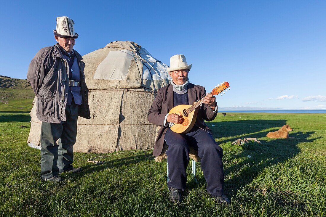 Kirgisistan, Provinz Naryn, Son-Kol See, Höhe 3000m, Kirgisischer Mann spielt Gitarre vor einer Jurte