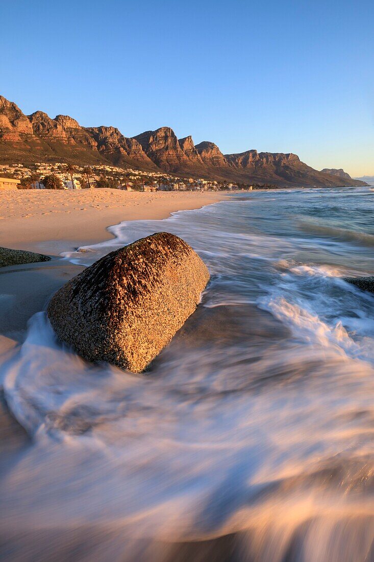 Südafrika, Westkap, Zeitlupe auf einem Felsen am Camps Bay Beach, Kapstadt, am Fuße des Tafelbergs bei Sonnenuntergang