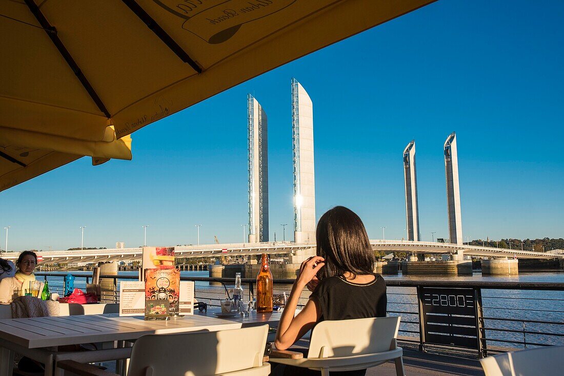 Frankreich, Gironde, Bordeaux, die Hubbrücke Jacques Chaban Delmas überspannt die Garonne von einer Bistroterrasse am Kai aus gesehen