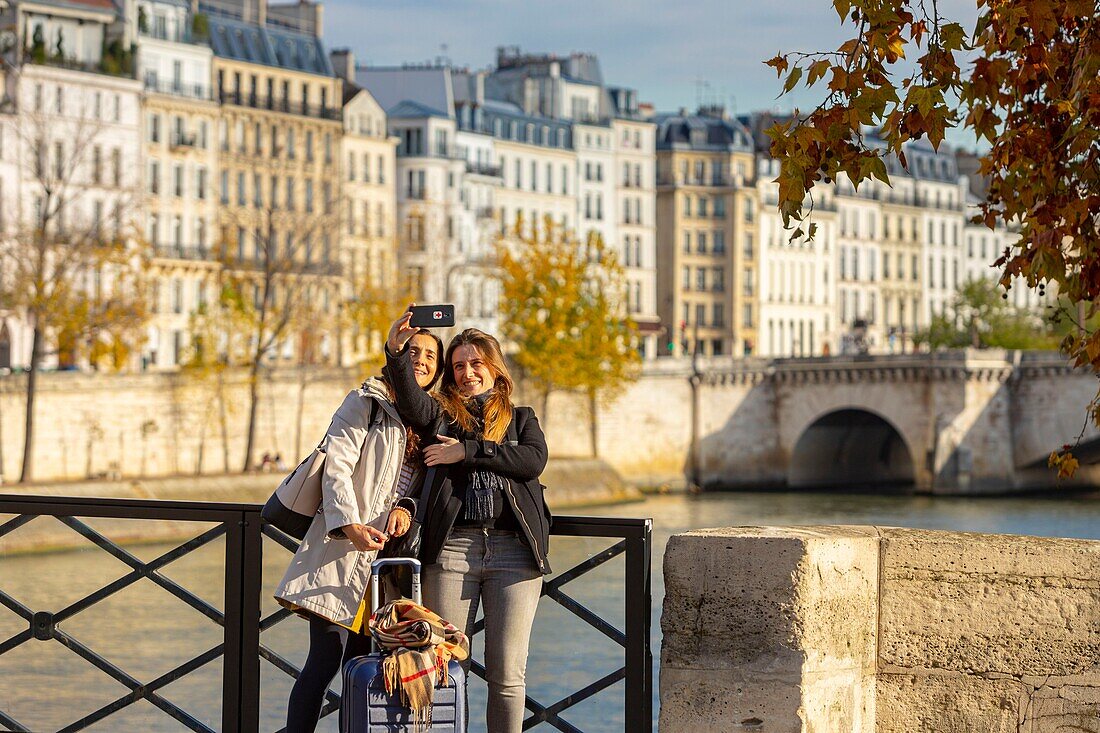 France, Paris, selfie of young girls on the Quays of the Seine in autumn