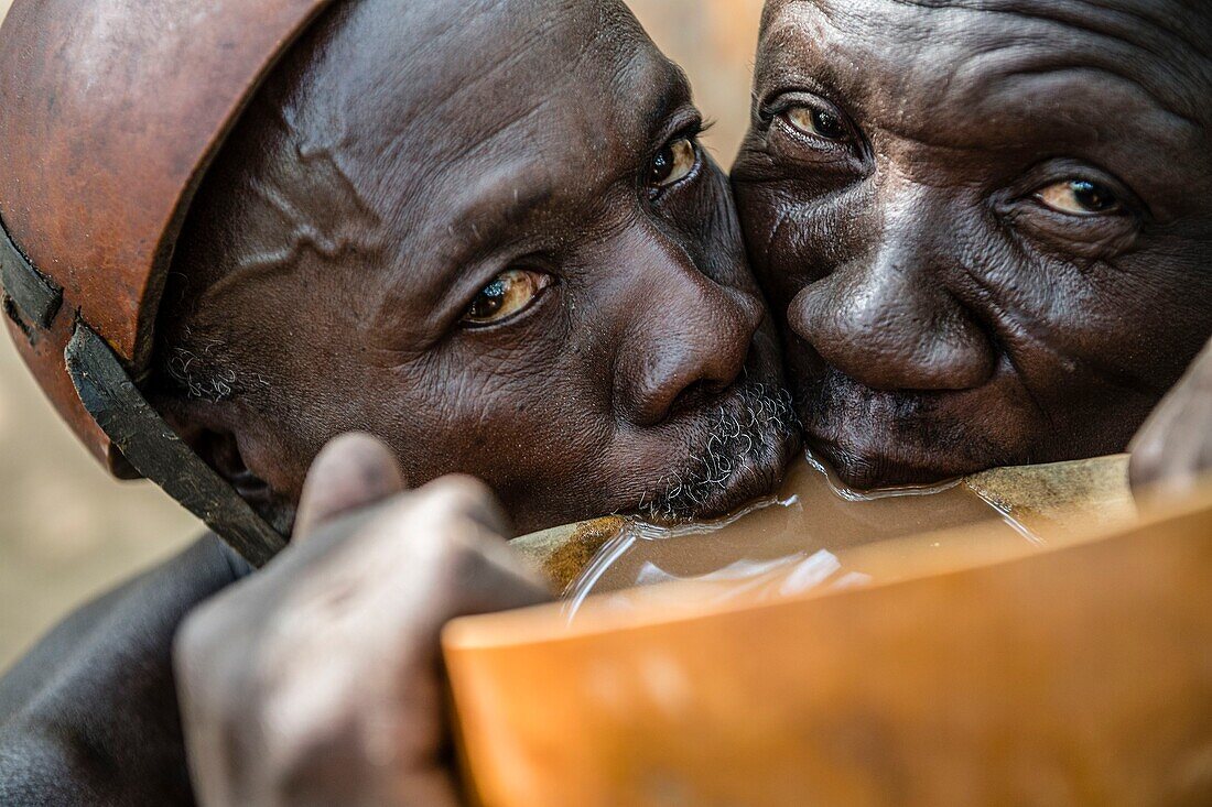 Benin, Nördlicher Bezirk, Atacora-Gebirge, Copargo, traditionelle Heiler vom Stamm der Taneka trinken gemeinsam Hirsebier namens Tchoukoutou