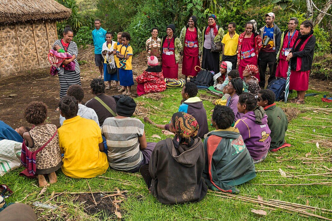 Papua-Neuguinea, Western Highlands Province, Mendi, Dorf Tambul, &#x2018;Savings Lives, Spreading Smiles' Programm wird durchgeführt, um Müttern zu helfen, ihre Babys vor Hyperthermie zu schützen. Das von UNICEF entwickelte einfache Gerät namens &#x2018;Bebi Kol Kilok" besteht aus einem Armband, das die Eltern bei einem Absinken der Körpertemperatur ihres Neugeborenen alarmiert. Freiwillige Helfer aus der Gemeinde wurden geschult, um die Mütter in der Verwendung des Geräts und in der Erwärmung ihrer Babys zu unterweisen.