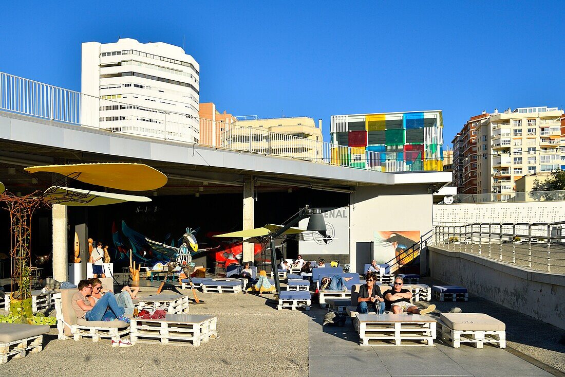 Spain, Andalusia, Costa del Sol, Malaga, the waterfront on the port, El Artsenal, bar, art gallery and The Pompidou Art Centre the Cube by Daniel Buren in the background