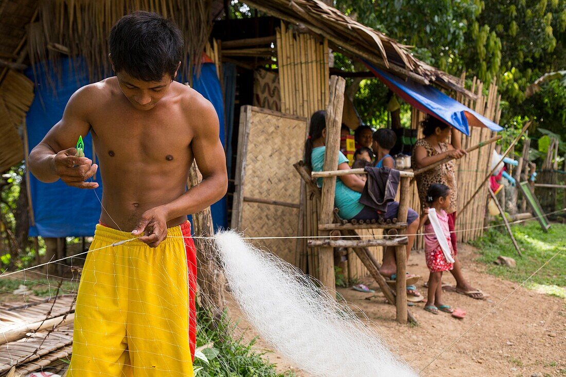 Philippinen,Palawan,Malampaya Sound Protected Landscape and Seascape,Junge repariert Fischnetz