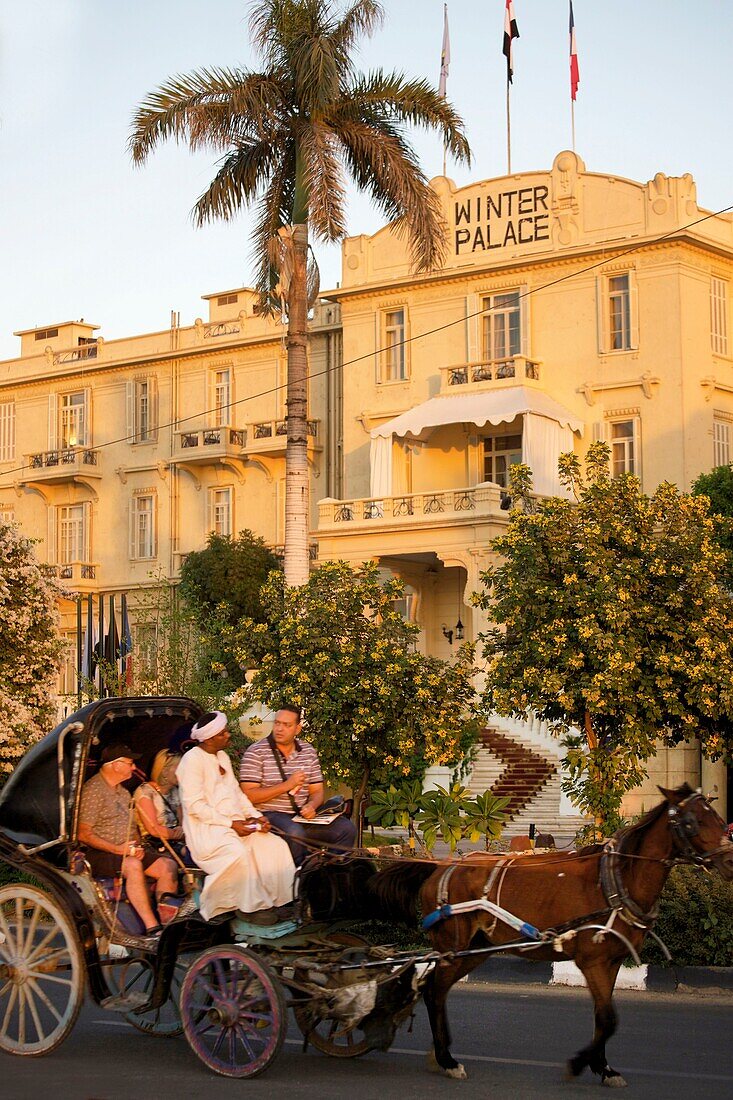 Ägypten,Oberägypten,Niltal,Luxor,Touristen in einer Pferdekutsche vor der Hotelfassade des Winterpalastes