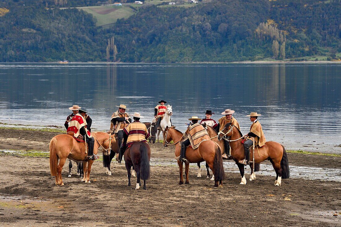 Chile,Region Los Lagos,Archipel von Chiloe,Insel Quinchao,Curaco de Velez,huasos (Reiter) mit chupalla und manta vor einer Parade