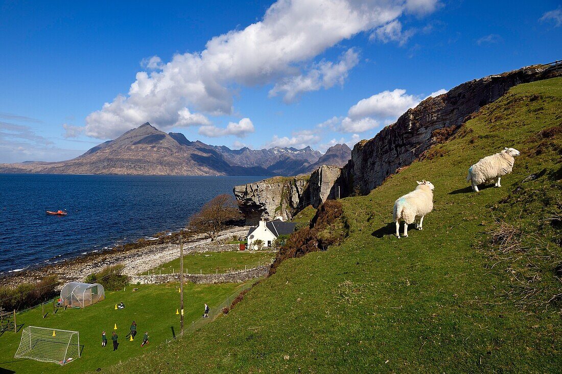 Vereinigtes Königreich,Schottland,Highlands,Hebriden,Isle of Skye,Dorf Elgol am Ufer des Loch Scavaig gegen Ende der Halbinsel Strathaird und die Black Cuillin Mountains im Hintergrund,Kinder spielen im Schulgarten Rounders