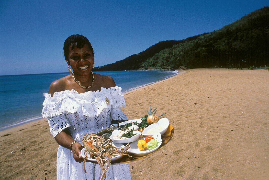 L.Salcede mit Meeresfrüchtegerichten am Strand von Guadeloupe