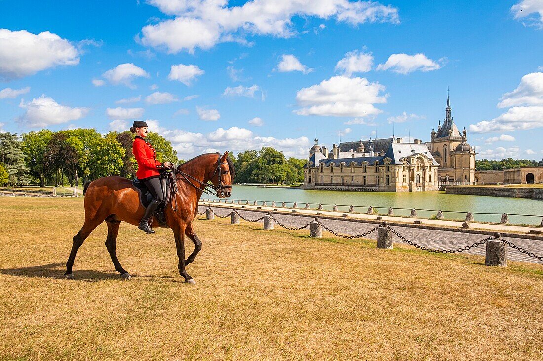 France, Oise, Chantilly, Chateau de Chantilly, the Grandes Ecuries (Great Stables), Clara rider of the Grandes Ecuries, runs his horse at the Spanish pace in front of the castle