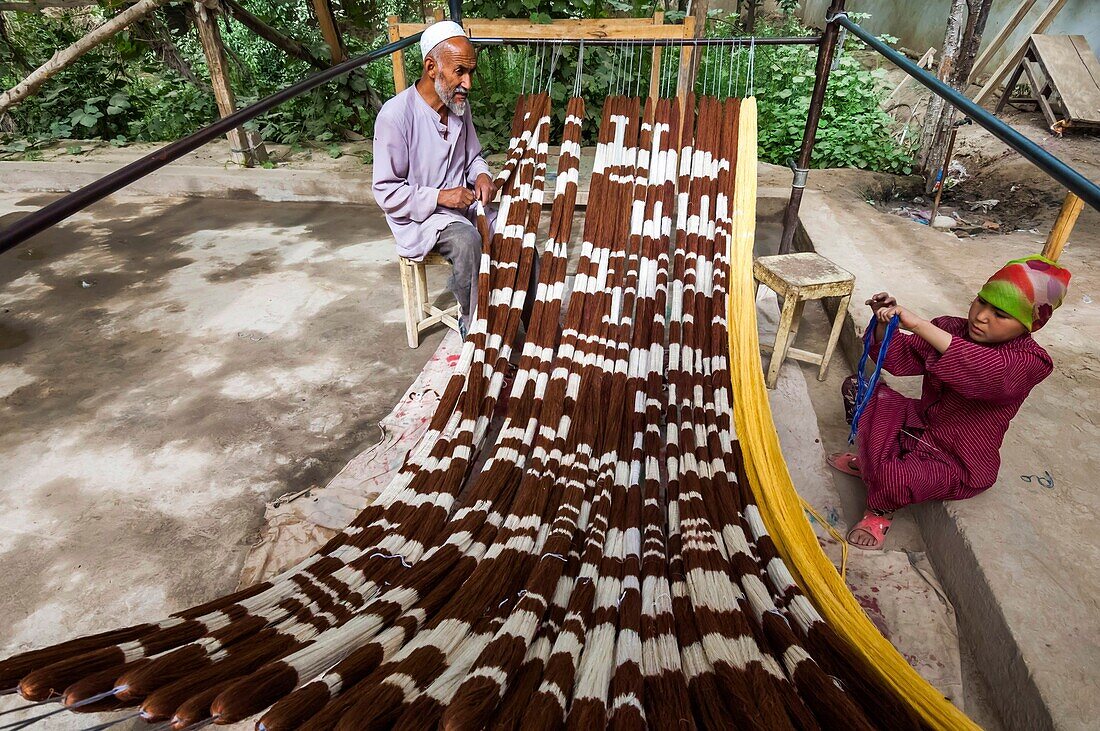 China, Xinjiang autonomous region, Hotan, traditional workshop for silk production, threading, dyeing and weaving