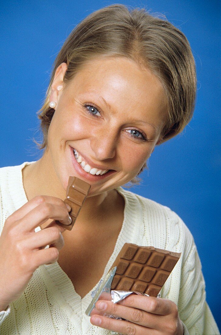 Junge blonde Frau mit Milka-Schokolade