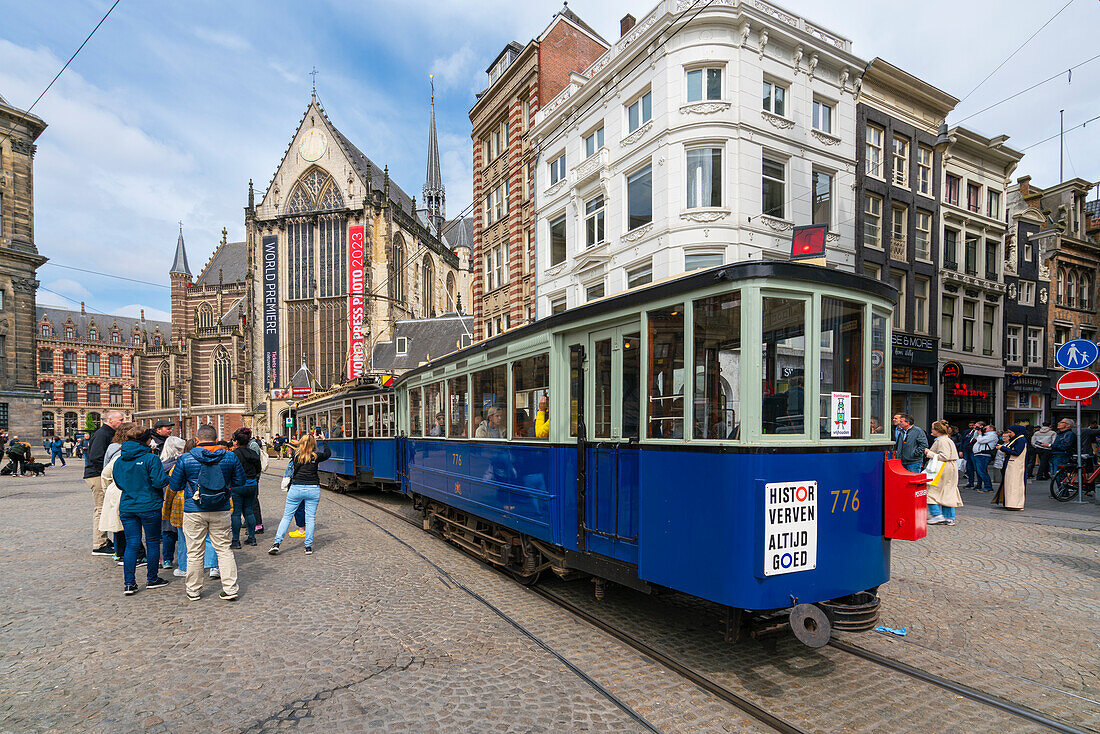 Blaue Straßenbahn und die Neue Kirche (De Nieuwe Kerk) im Hintergrund am Dam-Platz,Amsterdam,Niederlande,Europa