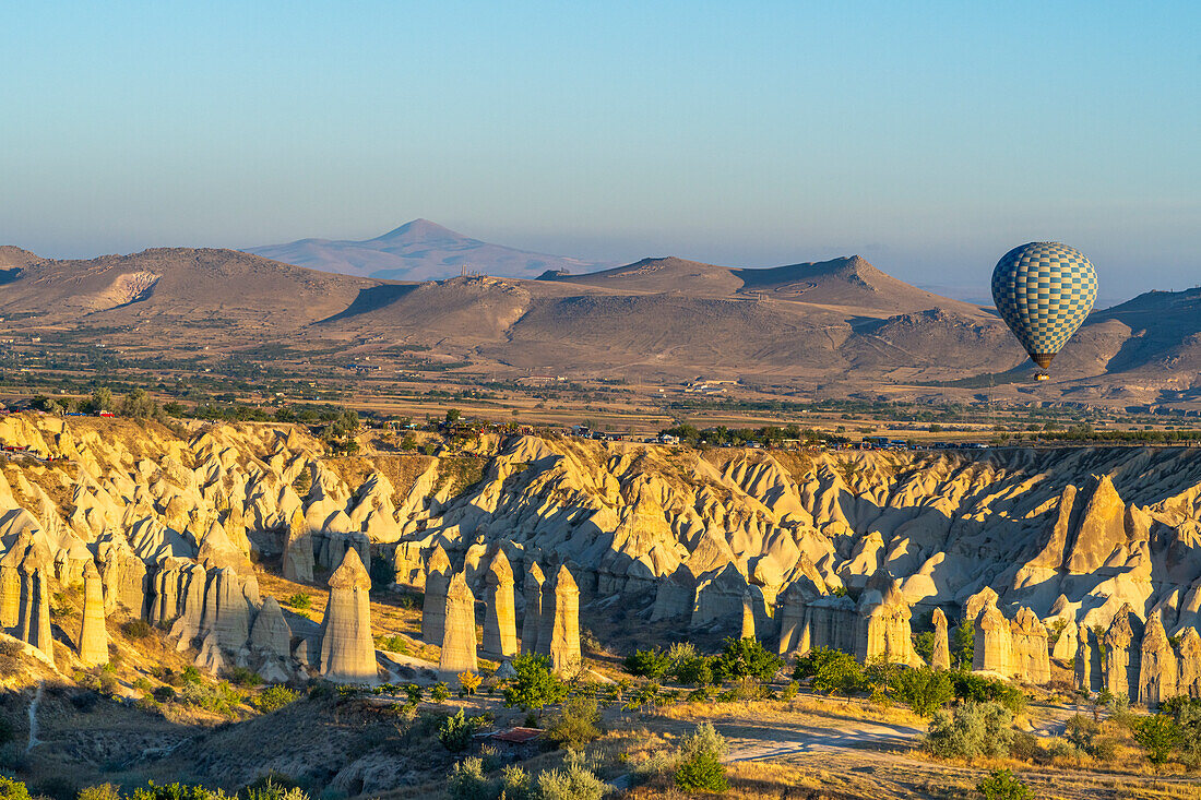 Luftaufnahme eines Heißluftballons über Felsformationen im Tal der Liebe bei Sonnenaufgang,Goreme,Goreme Historical National Park,UNESCO Weltkulturerbe,Kappadokien,Region Zentralanatolien,Anatolien,Türkei,Kleinasien,Asien