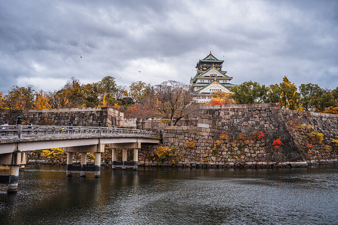 Beautiful Osaka Castle moat in autumn (fall) with bridge leading over the waters towards the Samurai Castle, Osaka, Honshu, Japan, Asia