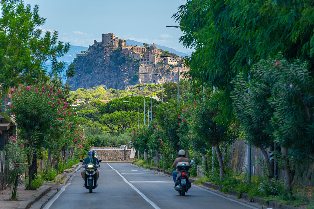 Blick auf Motorrollerfahrer und das Castello Aragonese d'Ischia vom Porto d'Ischia (Hafen von Ischia),Insel Ischia,Kampanien,Italien,Europa