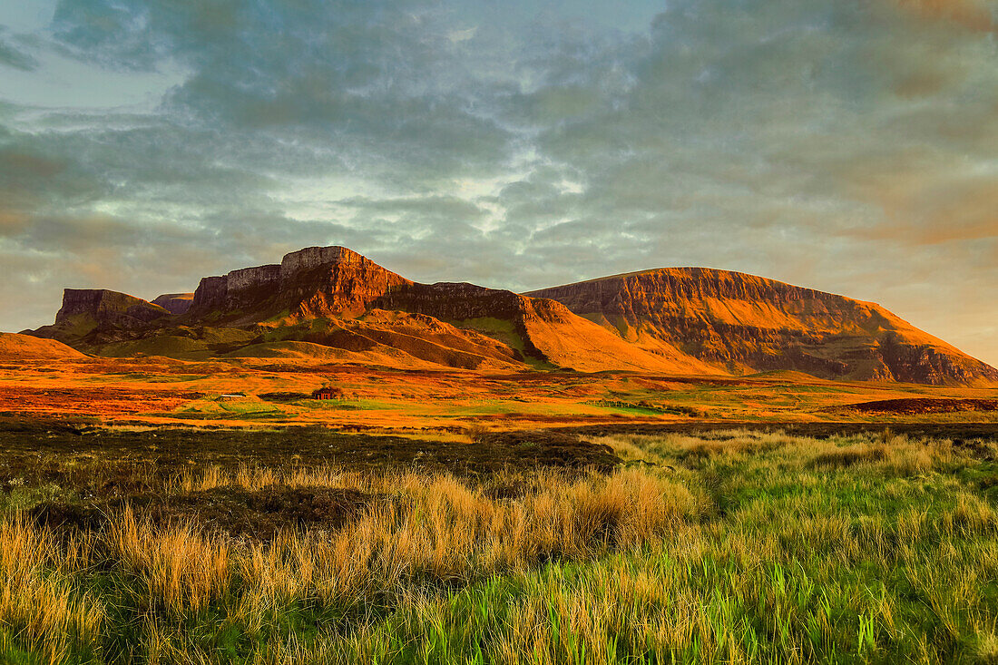 Die Trotternish Ridge,eine geologische Besonderheit aus Lavaströmen über jurassischen Sedimenten,eine wichtige landschaftliche Attraktion im äußersten Nordosten der Insel bei Sonnenuntergang Goldene Stunde,Flodigarry,Trotternish Peninsula,Skye,Innere Hebriden,Schottland,Vereinigtes Königreich,Europa