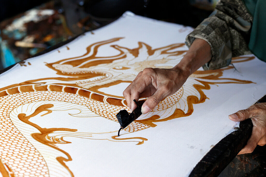 Frau zeichnet mit heißem Wachs ein Drachenmuster,Batikherstellung,Yogyakarta,Java,Indonesien,Südostasien,Asien,Asien