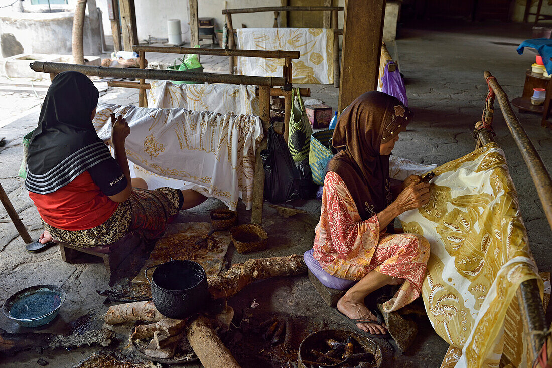 Women using pen-like tool (canting) to apply liquid hot wax to create pattern on fabric without preliminary drawing, Nyah Kiok batik house, craft production by seven women for over 30 years, Lasem, Java island, Indonesia, Southeast Asia, Asia