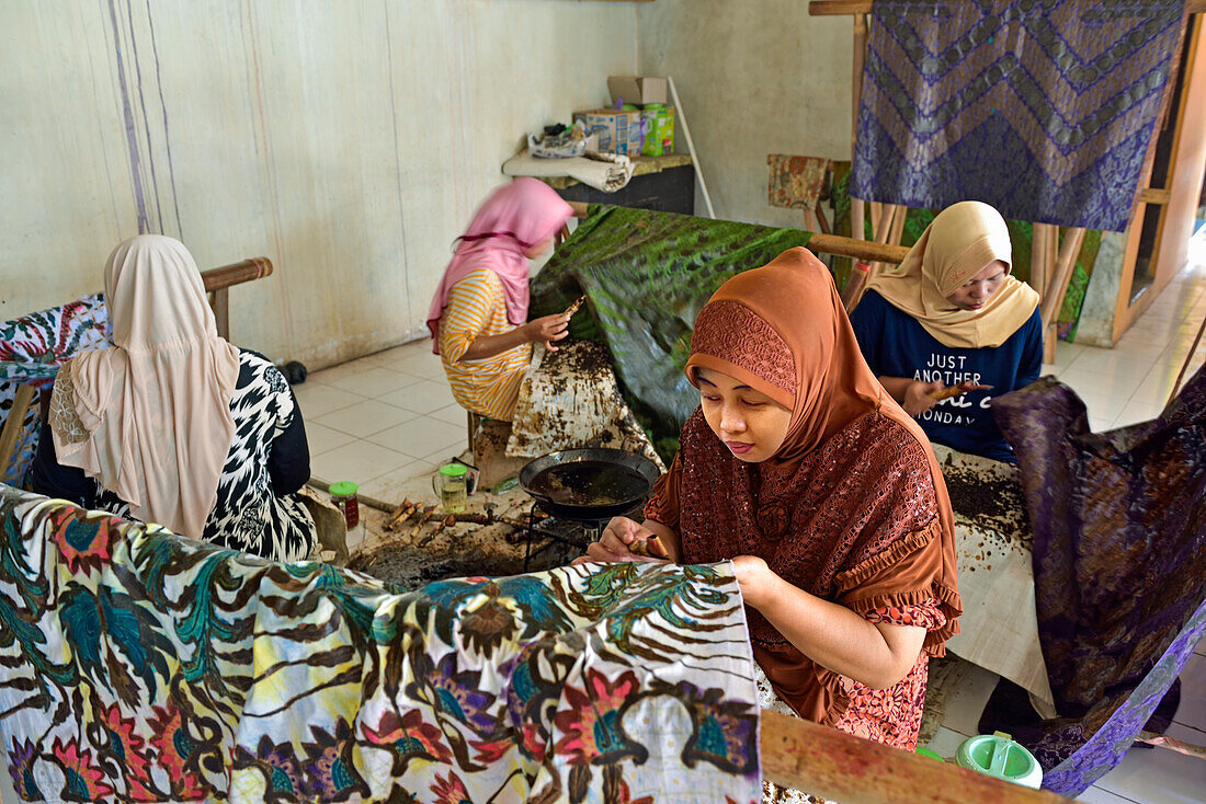 Women using a pen-like tool (canting) to apply liquid hot wax in the batik-making process, Wirakuto batik workshop, Pekalongan, Java island, Indonesia, Southeast Asia, Asia