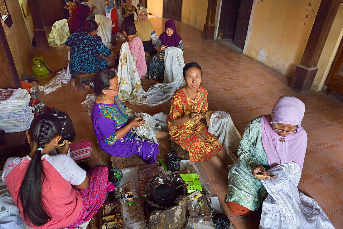 Frauen tragen mit einem stiftähnlichen Werkzeug (kantig) flüssiges Heißwachs bei der Batikherstellung auf,Wirakuto-Batikwerkstatt,Pekalongan,Insel Java,Indonesien,Südostasien,Asien