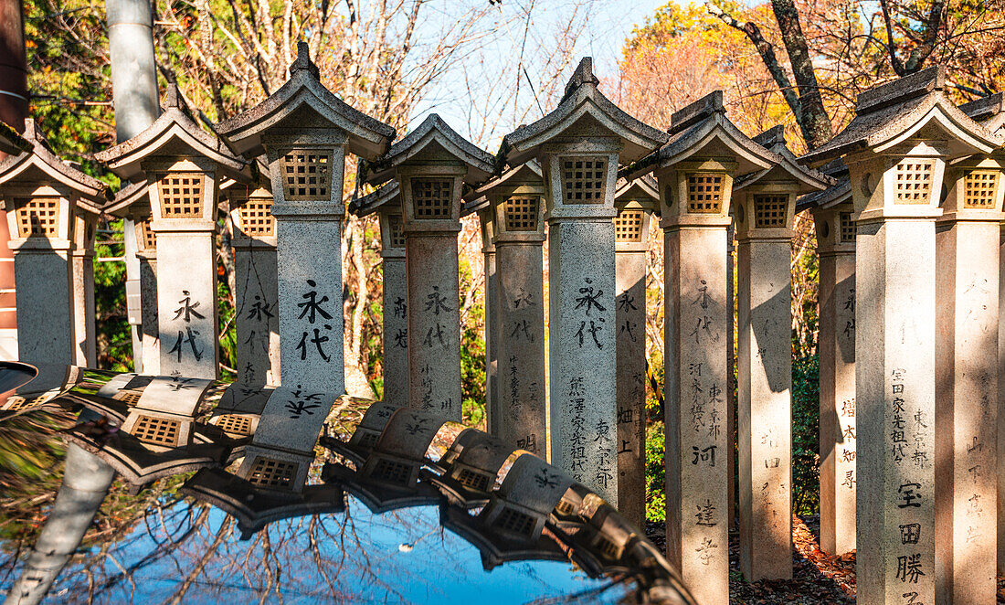 Reihe von Zen-Steinlaternen,die sich im Wasser spiegeln,Yoshino,Honshu,Japan,Asien