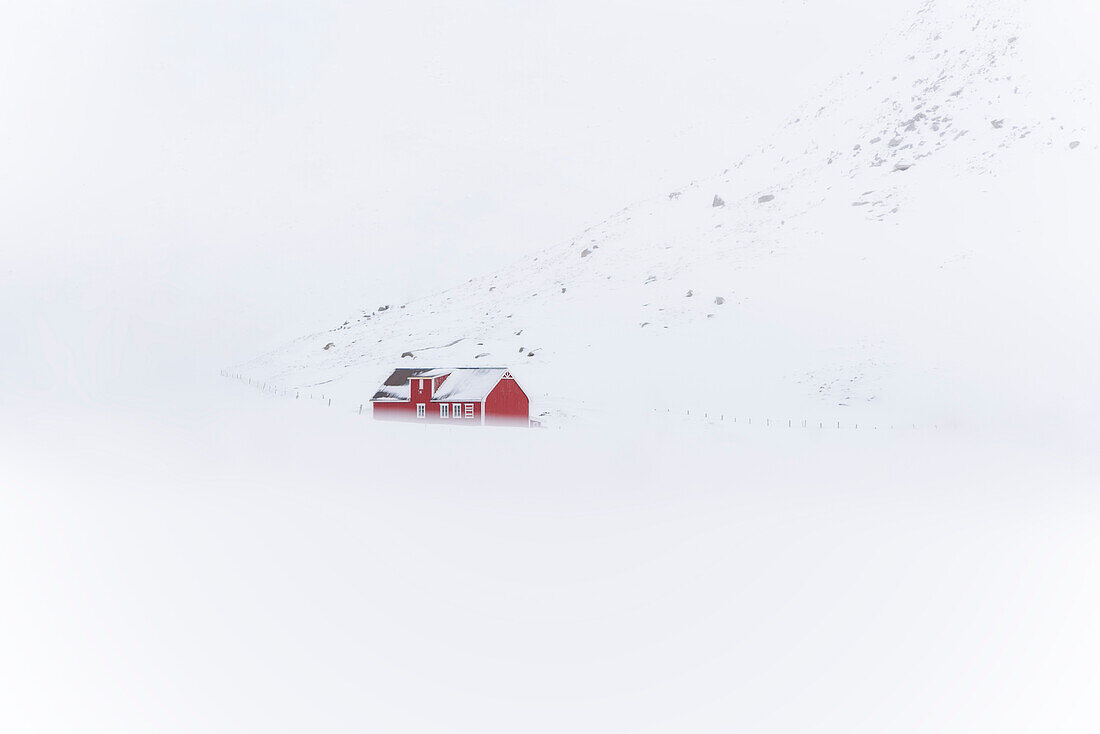 Eine rote Rorbu im Schnee am Skagsanden Strand,Flakstad,Flakstadoya,Nordland,Lofoten,Norwegen,Europa