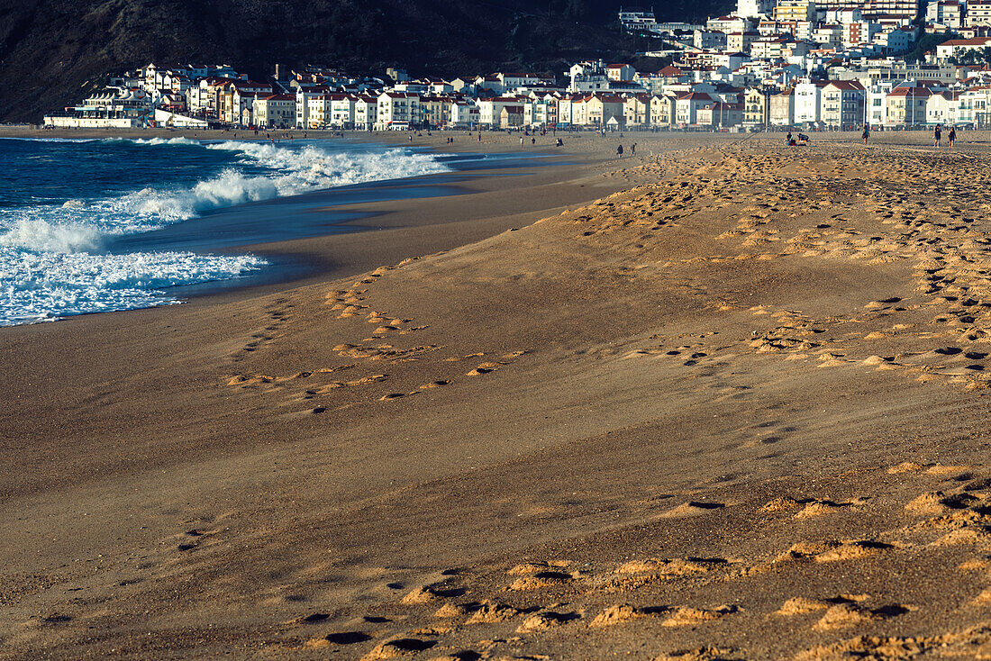 Selective focus view of the beach with fishing town of Nazare in the background, known for the largest waves in the world, Nazare, Oeste, Estremadura, Portugal, Europe