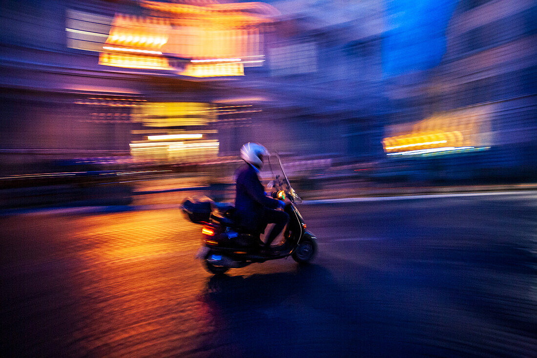 A scooter swiftly glides through the lively streets of Rome, capturing the city's evening ambiance and motion.