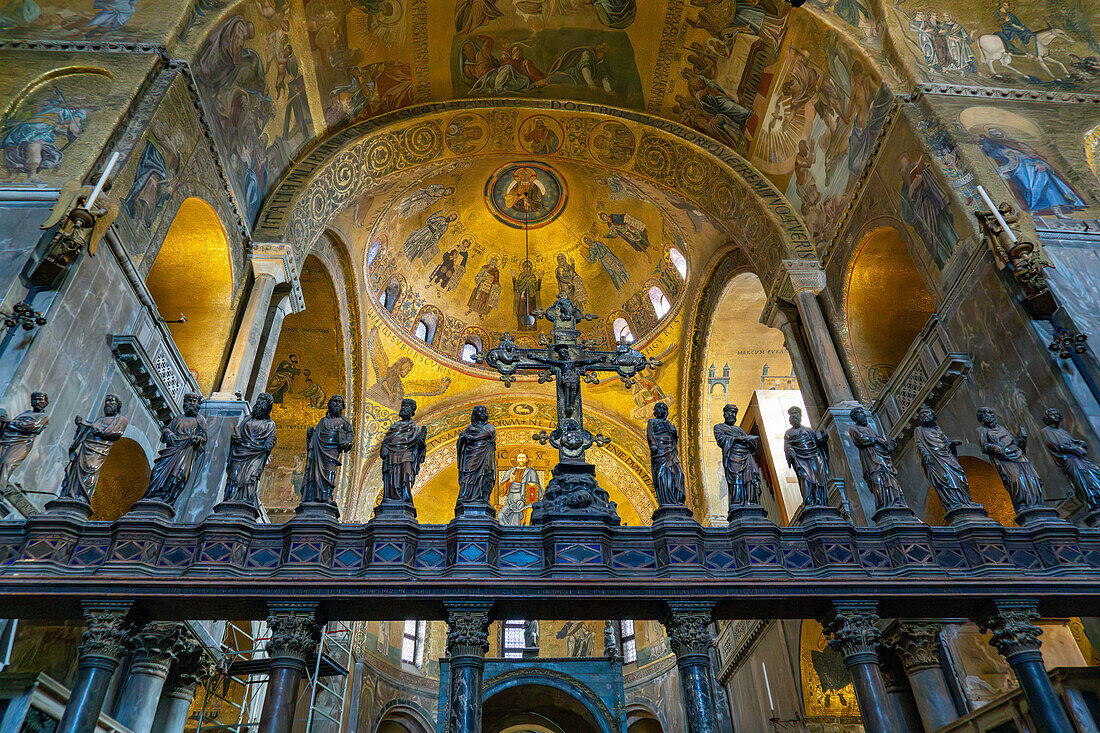 Das silberne und bronzene Kruzifix auf dem gotischen Altarschirm des Markusdoms in Venedig,Italien. Zu beiden Seiten befinden sich Statuen der Jungfrau Maria und der zwölf Apostel.