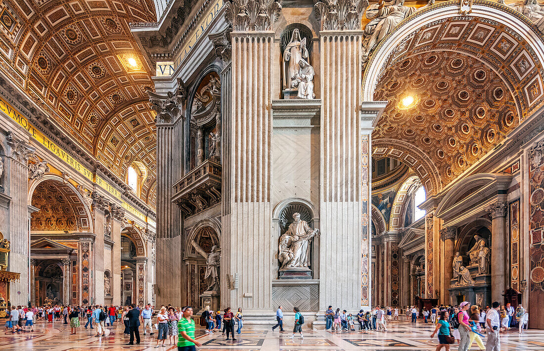 Rome, Italy, July 22 2017, Tourists admire the majestic interior of St. Peter's Basilica in Rome. Featuring St. John of God and St Andrew statues in the middle.