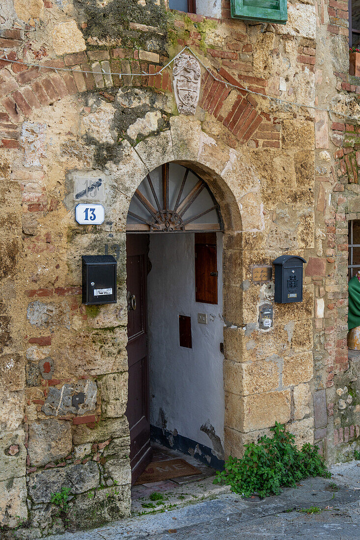 Hölzerne Tür eines Wohnhauses in der mittelalterlichen Stadt Monteriggioni,Siena,Toskana,Italien.