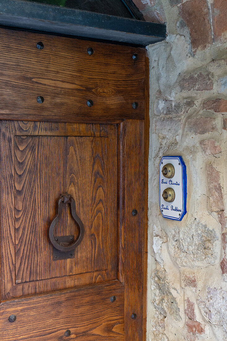 Wooden doorway of a residence in the medieval walled town of Monteriggioni, Sienna, Tuscany, Italy.