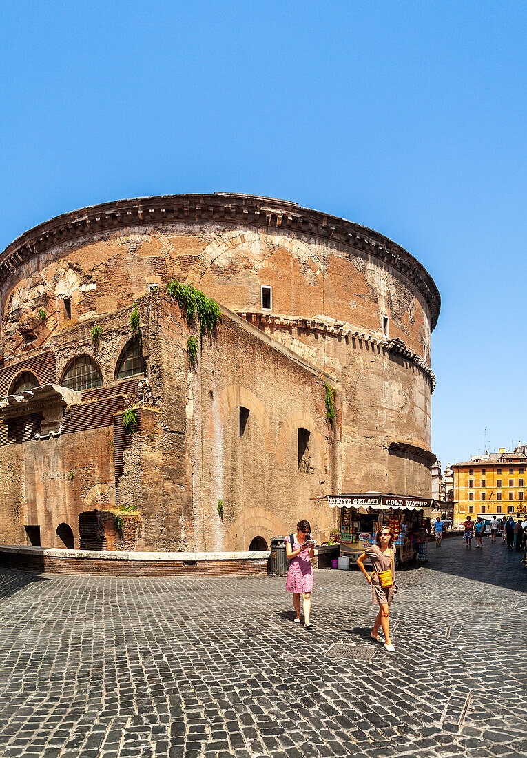 Rome, Italy, July 2017, Visitors stroll past the historic rear of the Pantheon, surrounded by the vibrant atmosphere of Rome on a sunny day.