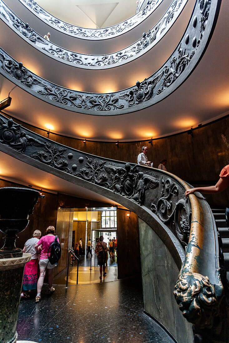 Rom,Italien,22. Juli 2017,Besucher navigieren über die elegante Wendeltreppe in den Vatikanischen Museen,die ein kompliziertes Design vor einem modernen Hintergrund zeigt.