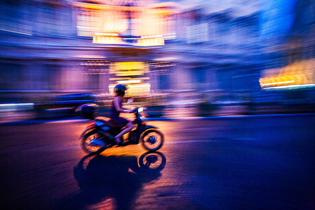 Ein Motorroller rast durch die pulsierenden Straßen Roms und fängt die Essenz der Stadt in der Abenddämmerung mit ihrem bezaubernden Glanz ein.