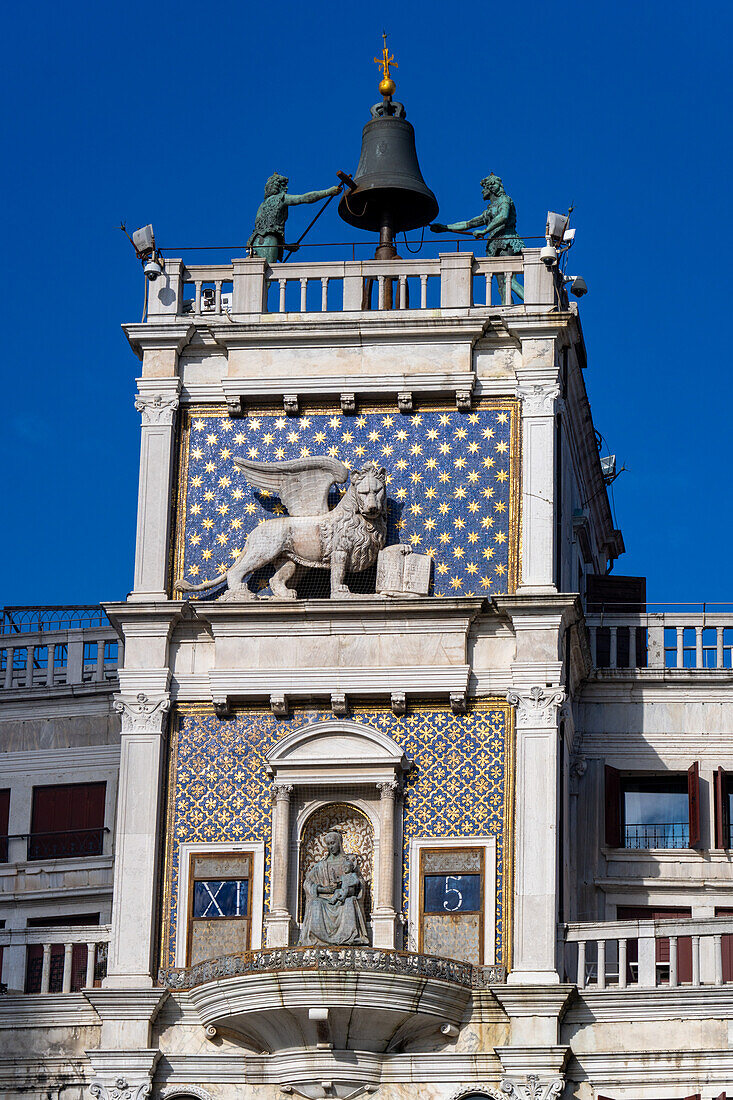 Detail des Uhrenturms auf dem Markusplatz in Venedig,Italien,mit dem Markuslöwen,der die Glocke läutet.