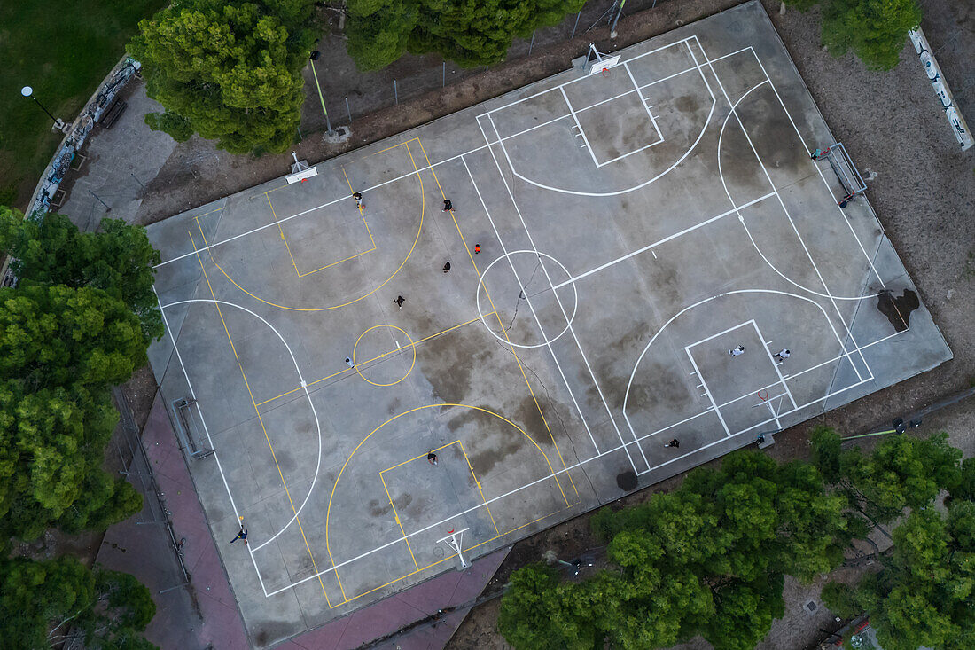 Basketball and soccer exterior courts among trees in city park, Zaragoza, Spain