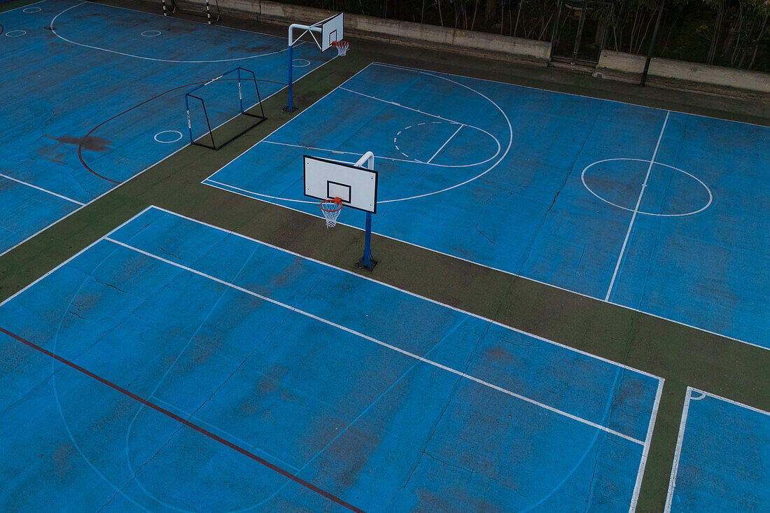 Aerial view of blue basketball and sports courts in school playground