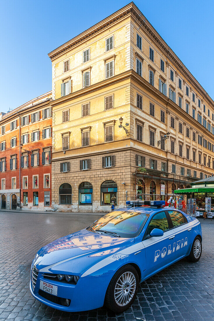 Rome, Italy, July 2017, A police car stands near Piazza di Spagna, while visitors explore the vibrant square filled with activity.