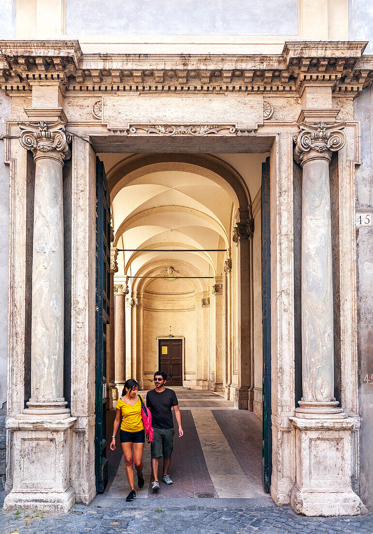 Rome, Italy, July 2017, Two visitors stroll through the grand entrance of the Santa Maria della Concezione church in Rome, enjoying the architectural beauty.