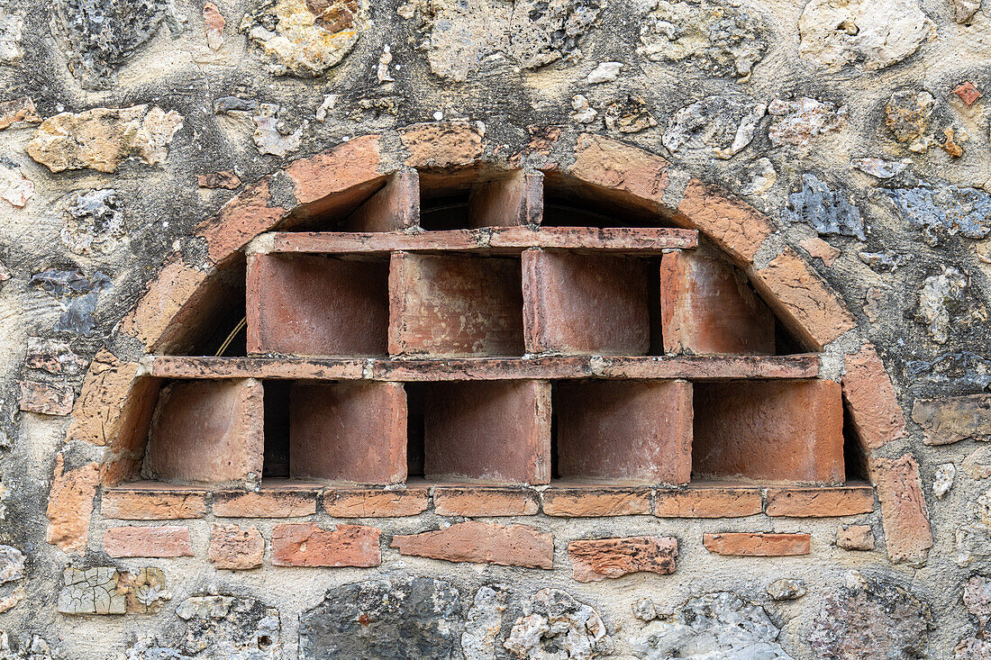 Unique window in a building in the medieval walled town of Monteriggioni, Sienna, Tuscany, Italy.