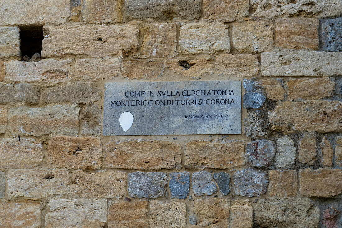 A stone plaque with a quote from Dante's Inferno about Monteriggioni. Monteriggioni, Sienna, Tuscany, Italy.