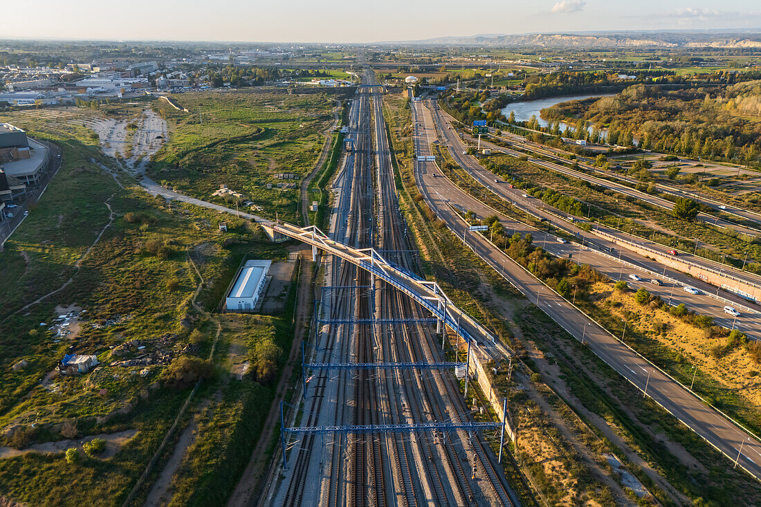 Blick aus der Luft auf eine Brücke über die Bahngleise bei Sonnenuntergang