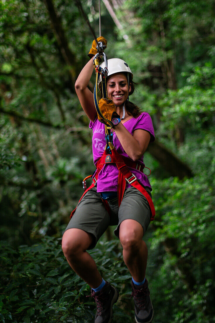 Young caucasian woman having fun during a Canopy tour in Costa Rica