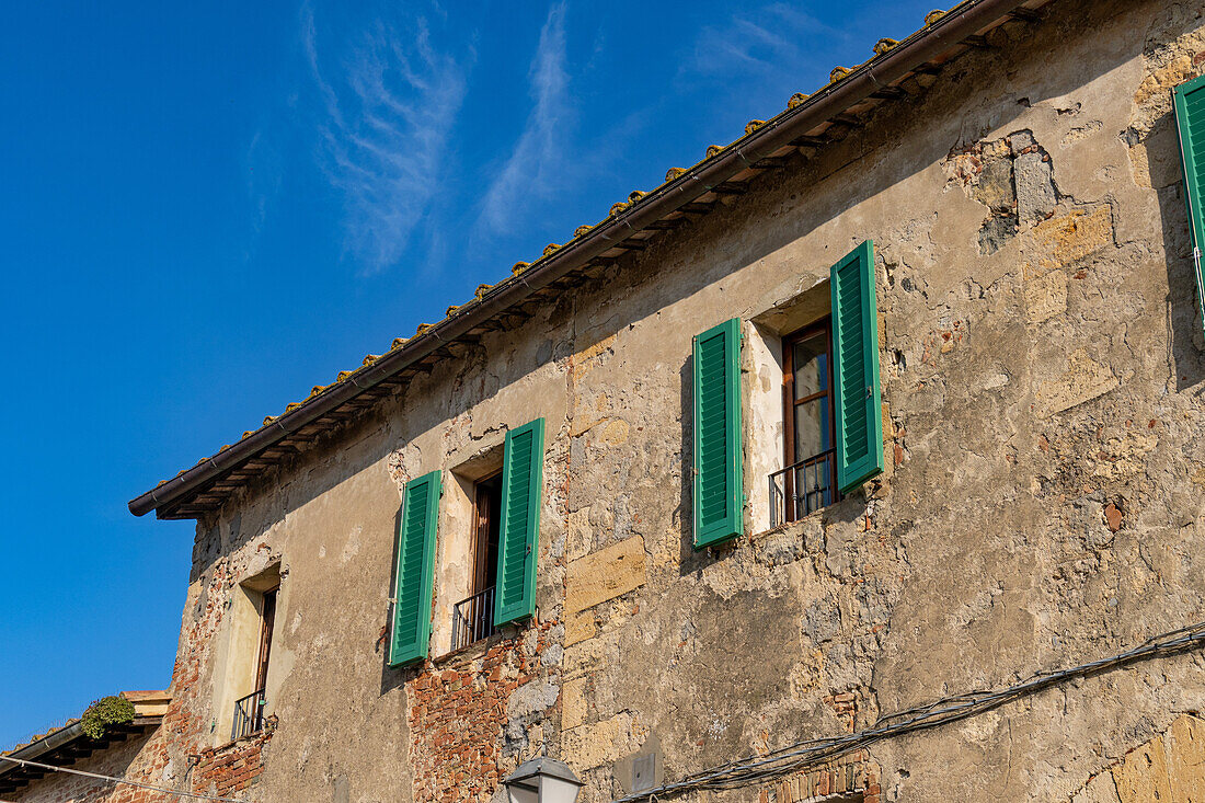 Wooden shutters on a building in the medieval walled town of Monteriggioni, Sienna, Tuscany, Italy.